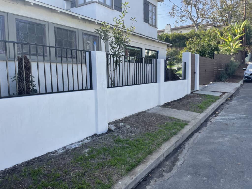 wrought iron and stucco front yard fence
